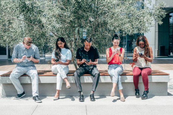 Group of diverse people using smartphones representing niche online community engagement