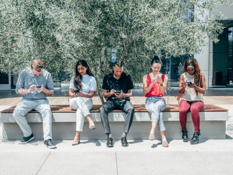 Group of diverse people using smartphones representing niche online community engagement