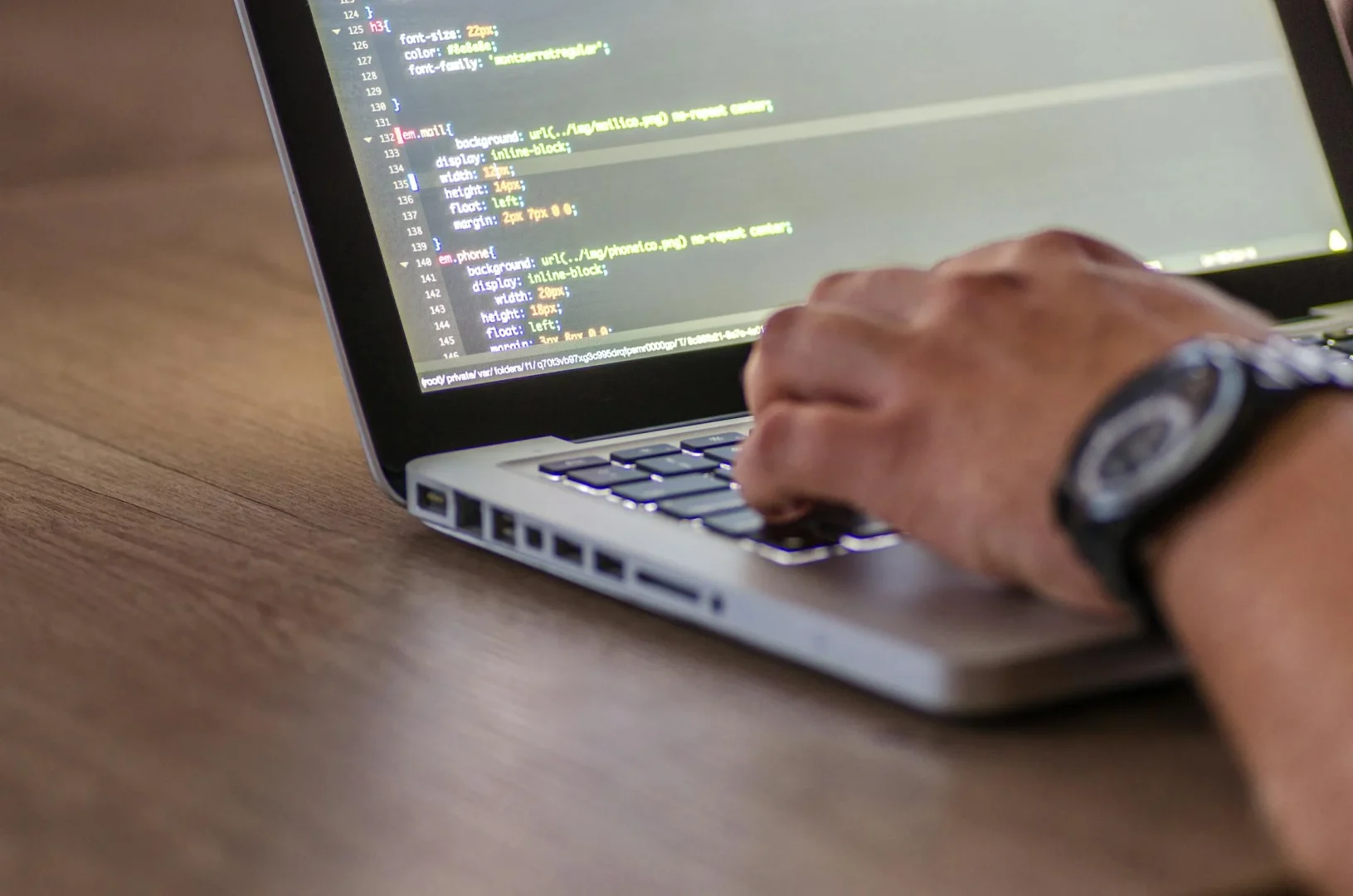 Developer using AI coding assistant on laptop with code on screen