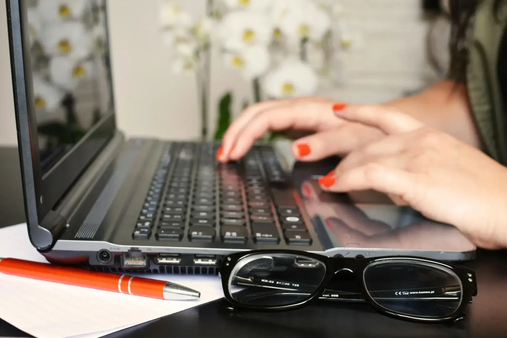 Writer working on laptop comparing QuillBot and Grammarly AI writing tools