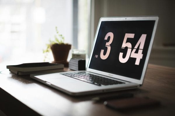 Modern workspace with laptop and clock representing time tracking software comparison