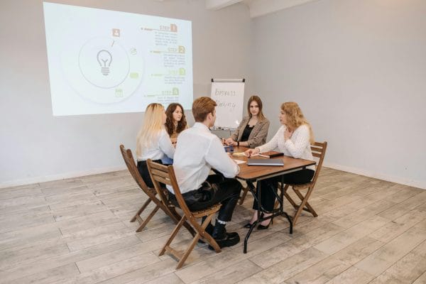 Business meeting with presentation screen comparing AI presentation tools