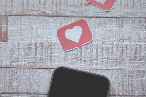 Smartphone with social media icons representing chat marketing platforms