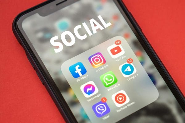 Smartphone with social media apps representing chat marketing vs support platforms