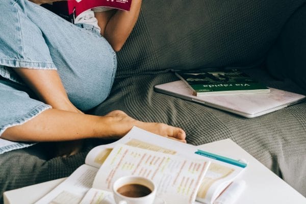 Woman studying language with coffee and books representing language learning app comparison