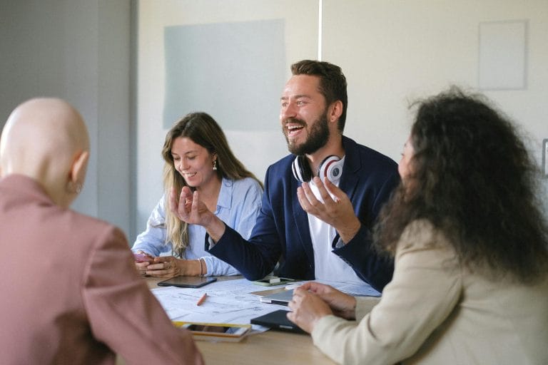 Happy colleagues collaborating in office representing employee engagement platforms