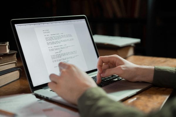 Writer typing on laptop representing AI content detection and verification