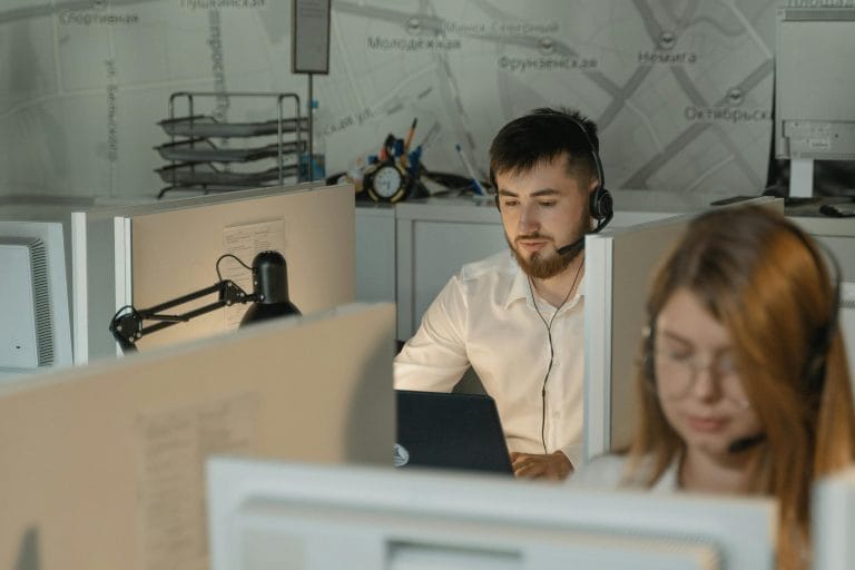 Customer service agents at desks representing help desk software comparison