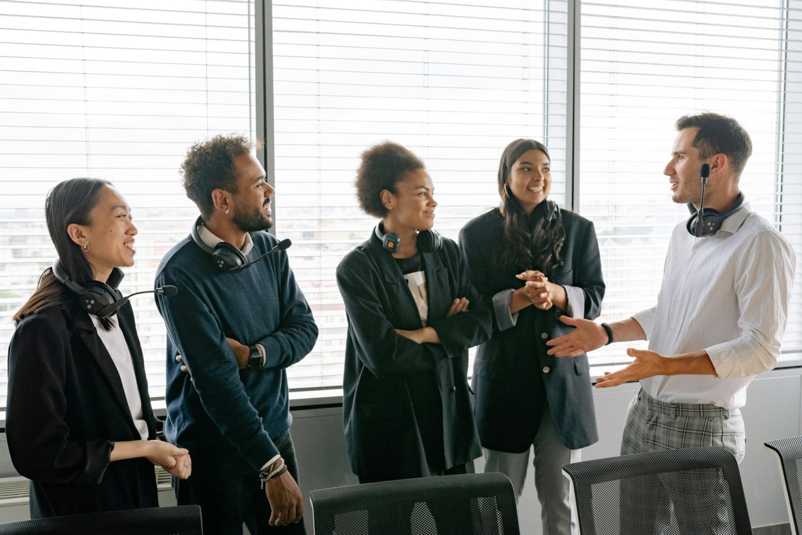 A diverse group of professionals having a conversation in a modern office environment.